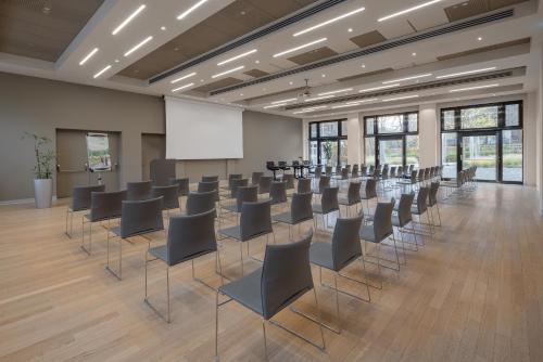 a conference room with chairs and a white screen at UNA Hotels Bologna Fiera in Bologna