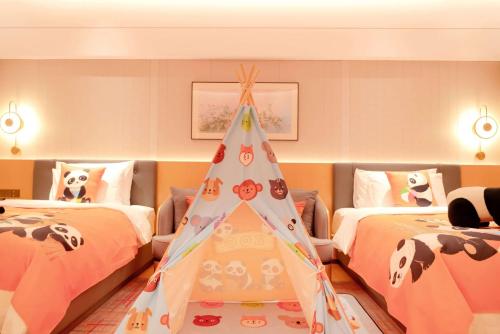 a room with two beds and a christmas tree at Wyndham Grand Zhaoqing Downtown in Zhaoqing