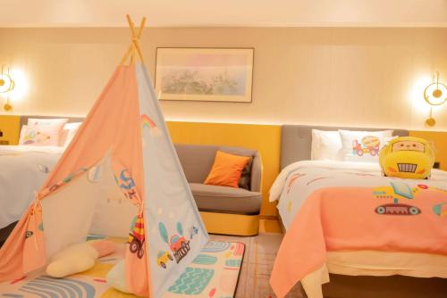 a childrens bedroom with two beds and a tent at Wyndham Grand Zhaoqing Downtown in Zhaoqing