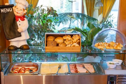 a buffet with a chef and a box of food at NATURION Hotel Hinterzarten in Hinterzarten