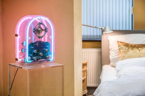 een kamer met een klok op een tafel naast een bed bij Das KONTOR in Bremen