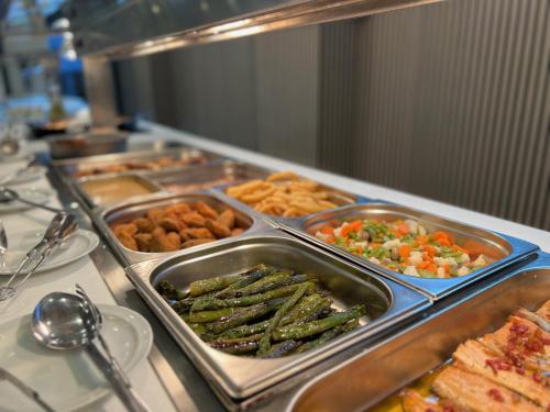 a buffet with several trays of vegetables and other food at Hotel Montesol Benidorm in Benidorm