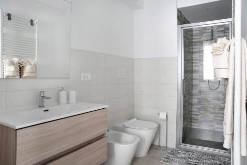 een badkamer met een toilet, een wastafel en een douche bij Casa Vacanze La Porta in Piazza in Guarene