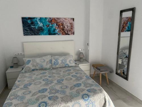 ein Schlafzimmer mit einem Bett und einem Wandgemälde in der Unterkunft TURISMO LOS LANCES TARIFA( PARKING GRATUITO) in Tarifa
