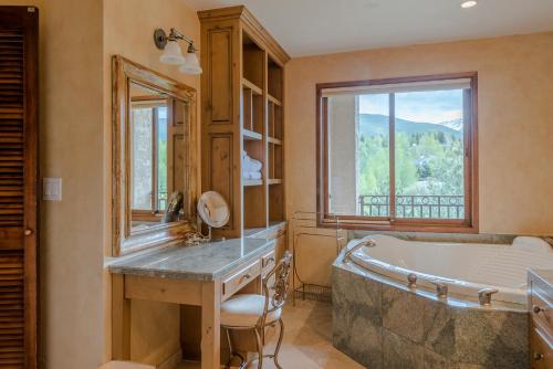 uma casa de banho com uma banheira, um lavatório e uma janela em Summit Condo 2815 em Elkhorn Village