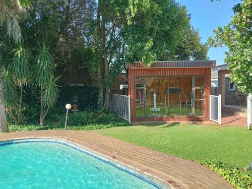 a small house with a pool in a yard at Harmony Place in Klerksdorp