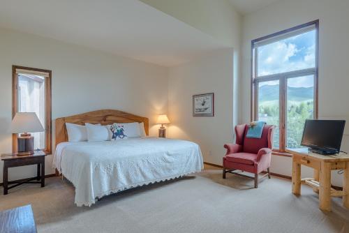 um quarto com uma cama, uma cadeira e uma televisão em Summit Condo 2815 em Elkhorn Village