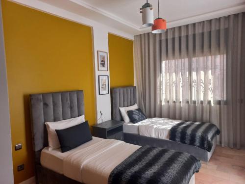 - une chambre avec 2 lits et une fenêtre dans l'établissement Belle Vue, à Marrakech