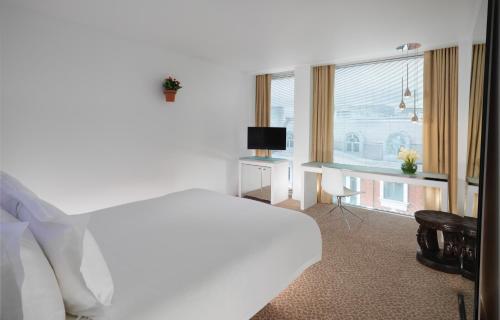a bedroom with a bed and a desk and a window at St Martins Lane London in London