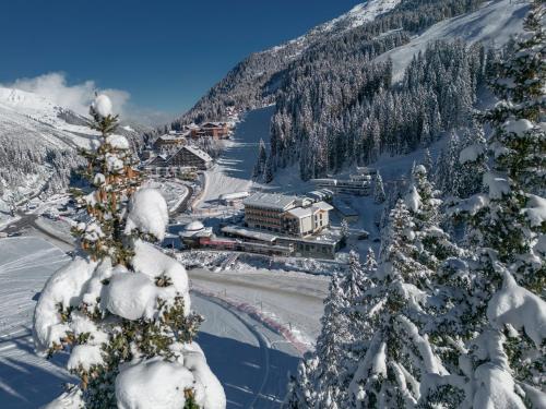 a ski resort in the mountains with snow covered trees at Berghotel Hochfügen in Hochfugen