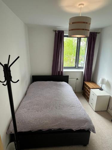 a bedroom with a bed and a large window at Charming bedroom in a shared 2-Bedroom Flat in Southall, London (next to Ealing Hospital). in London