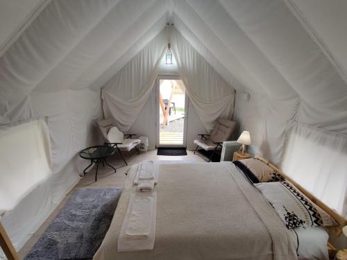 a bedroom with a large bed in an attic at PINIALE GLAMPING TRIB in Bughea de Jos