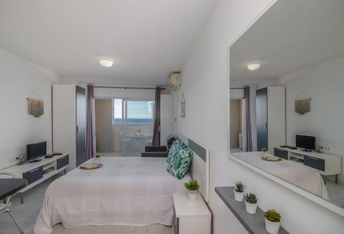 エンプリアブラバにある1810 Estudio con vistas al marの白いベッドルーム(大型ベッド1台、鏡付)