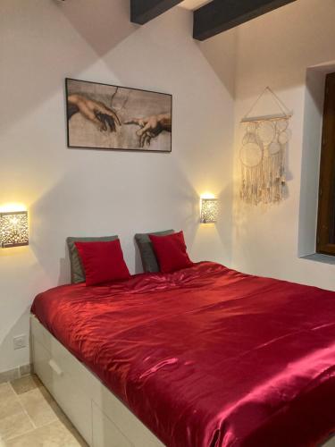 - une chambre avec un lit rouge et 2 oreillers rouges dans l'établissement La belle Maison d'Hôtes d'Aurélie avec SPA professionnel en pleine campagne et proche de tout, à Roquemaure