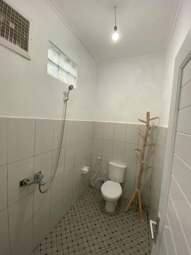 a bathroom with a toilet and a shower at Bali Bakas House II in Banjarangkan