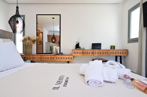 a bedroom with a bed with towels and a mirror at IL Vento Premium in Mikonos