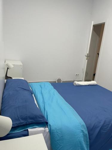 a bed with blue pillows in a room at Buen sitio para hospedarse in Barcelona