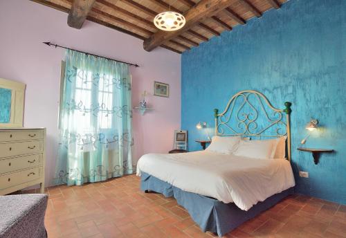 um quarto com uma cama com uma parede azul em Podere Benintendi em Certaldo