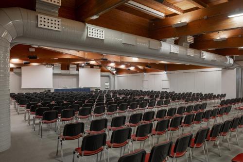 an empty lecture hall with rows of chairs at UNA Hotels Bologna San Lazzaro in San Lazzaro di Savena