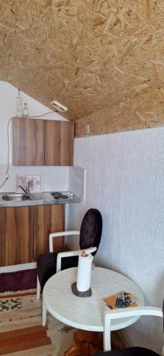 a room with a table and a chair and a kitchen at Medena oaza mira 2 in Visoko