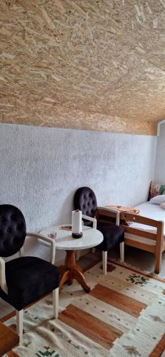 a room with two chairs and a table and a bed at Medena oaza mira 2 in Visoko