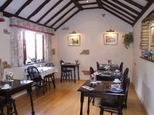 un comedor con mesas y sillas en una habitación en Cotswold House, en Oxford