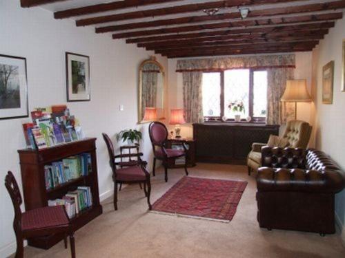 sala de estar con sofá, sillas y mesa en Cotswold House en Oxford