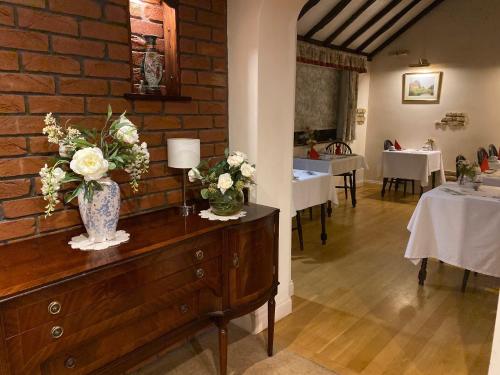 a room with a vase of flowers on a dresser at Cotswold House in Oxford