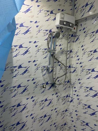 特馬的住宿－Kobbys Brands，浴室铺有蓝色和白色瓷砖,设有淋浴。