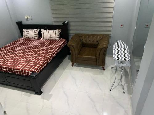 Kobbys Brands في تيما: غرفة نوم بسرير وكرسي
