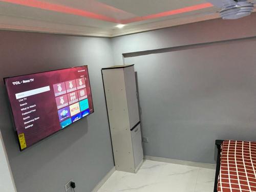 Kobbys Brands في تيما: غرفة بها تلفزيون على الحائط وباب