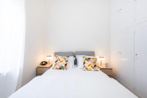 a bedroom with a white bed with two pillows at Kipstay Apartments in Athens