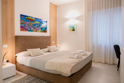 a bedroom with a large bed with white sheets at Lo Studio di viale Lo Re camere & caffe’ in Lecce