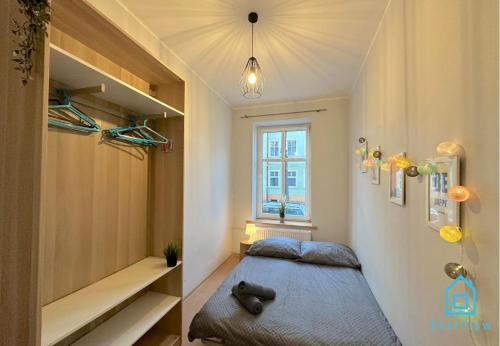 a small bedroom with a bed and a window at Butterfly Room in Gdańsk