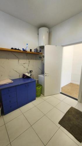 a kitchen with a blue cabinet and a white door at Rino's Apartment 1 in Shkodër
