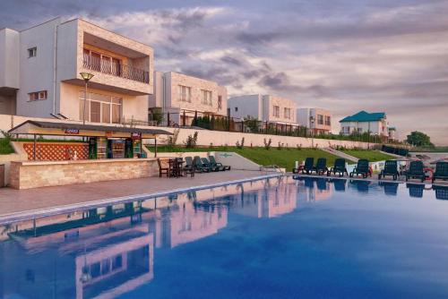 Ştefăneştii de Josにある2 Rooms A504 StayInn by Cosmopolisの建物の前に椅子が置かれたプール