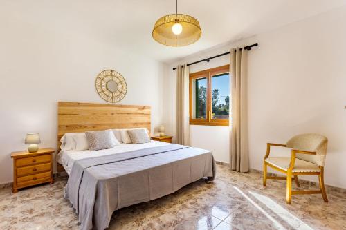 1 dormitorio con 1 cama, 1 silla y 1 ventana en Casa Far, en Portopetro