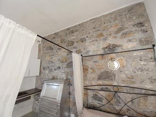 a room with a stone wall with a window and a curtain at Casa Sole di Toscana con 5 camere, grande terrazza panoramica, giardino e vasca relax idromassaggio in Monterotondo