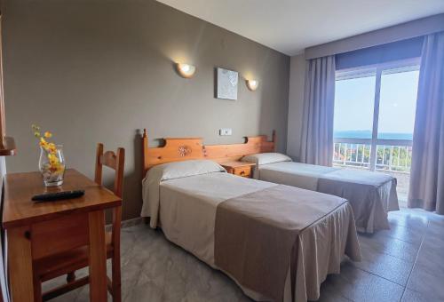 AiosにあるPensión Residencia Ceciliaのベッド2台とバルコニーが備わるホテルルームです。