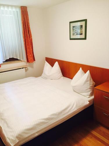 a bedroom with a bed with white sheets and a window at Pansion Danica in Rastovača