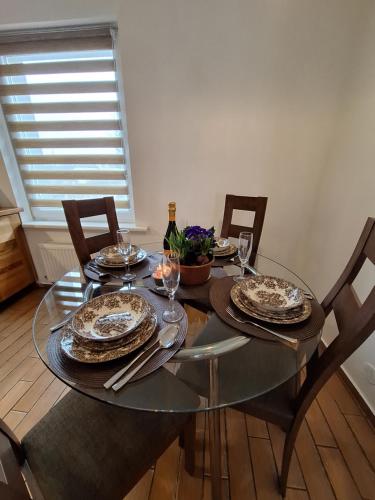 a dining room table with plates and wine glasses at Barona ielas apartamenti in Sigulda
