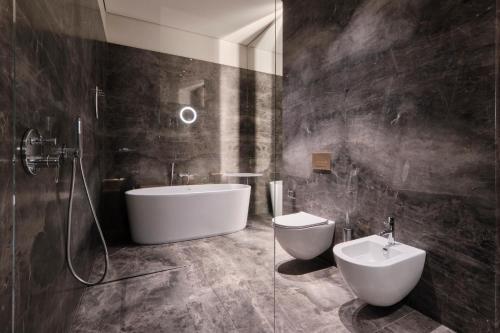 a bathroom with a tub and a toilet and a sink at Grand Hotel in Łódź