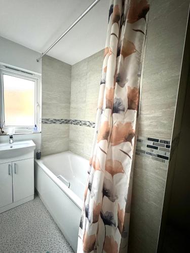 a bathroom with a tub and a shower curtain at The Singing Canary in London