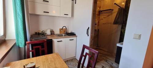 a small kitchen with a table and a counter top at Pensjonacik Ogrody in Pierzchno