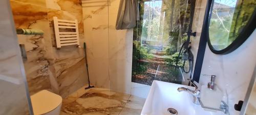 a bathroom with a sink and a window at Pensjonacik Ogrody in Pierzchno