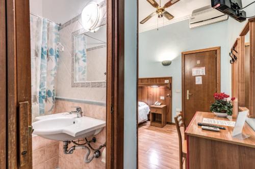 a bathroom with a sink and a bedroom at Hotel Altavilla in Rome