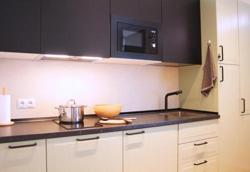 a kitchen with black cabinets and a bowl on a counter at Apartamento Marques de Zafra - Ventas in Madrid