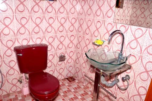 baño con aseo rojo y lavamanos en The Kings Villa, en Wattala