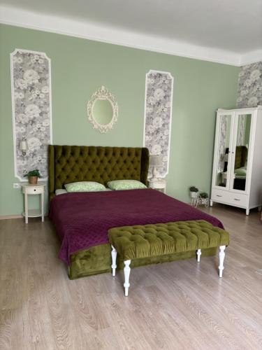 1 dormitorio con 1 cama grande con colcha púrpura en Edem Apartments in Lviv, en Leópolis