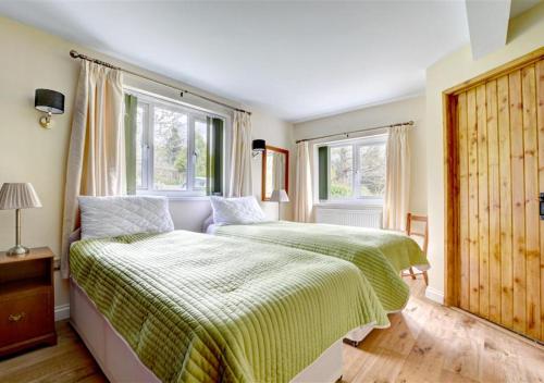 サンダースフットにあるStonecrossのベッドルーム1室(ベッド2台、窓2つ付)